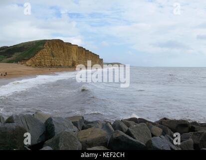 West Bay, Dorset, Großbritannien. Okt 2017 20. UK Wetter. Personen, die die relative Ruhe vor dem Sturm vorausgesagt, Großbritannien später heute auf einem sonnigen, aber stürmischen Tag am Strand zu schlagen. Credit: Dan Tucker/Alamy leben Nachrichten Stockfoto