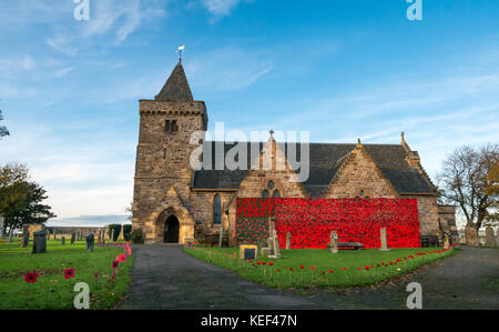 Aberlady, East Lothian, Schottland, Vereinigtes Königreich. 20 Okt, 2017. Aberlady Kirche und Friedhof mit Handgehäkelter roter Mohn von Aberlady Handwerk organisierte Gruppe eingerichtet, in Vorbereitung auf den Tag der Erinnerung und um Kapital für Mohnblume Schottland, auf einem sonnigen Herbsttag mit blauen Himmel. Die Außenseite der Kirche ist mit einem riesigen, aus Furcht daß wir Häkeln poppy banner Vergessen eingerichtet. Gewirken Mohn in den Grünstreifen der Kirchhof verstiftet Stockfoto