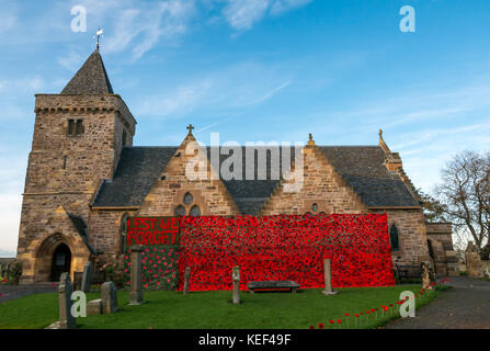 Aberlady, East Lothian, Schottland, Vereinigtes Königreich. 20 Okt, 2017. Aberlady Kirche und Friedhof mit Handgehäkelter roter Mohn von Aberlady Handwerk organisierte Gruppe eingerichtet, in Vorbereitung auf den Tag der Erinnerung und um Kapital für Mohnblume Schottland, auf einem sonnigen Herbsttag mit blauen Himmel. Die Außenseite der Kirche ist mit einem riesigen, aus Furcht daß wir Häkeln poppy banner Vergessen eingerichtet. Gewirken Mohn in den Grünstreifen der Kirchhof verstiftet Stockfoto