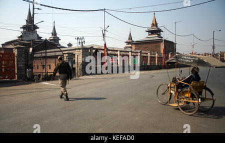 Srinagar, Kashmir. 21 Okt, 2017. eine indische paramilitärischen Soldat steht Alarm als Kaschmir behindert sein Fahrrad schiebt, während Beschränkungen in Teilen von Srinagar auferlegt. Normales Leben in Kaschmir Senke am Samstag wegen des Anrufs durch den separatistischen Führung gegen die unvermindert Geflecht hacken Vorfälle. Gutschrift ausgestellt für Streik betroffen war: sofi Suhail/alamy leben Nachrichten Stockfoto