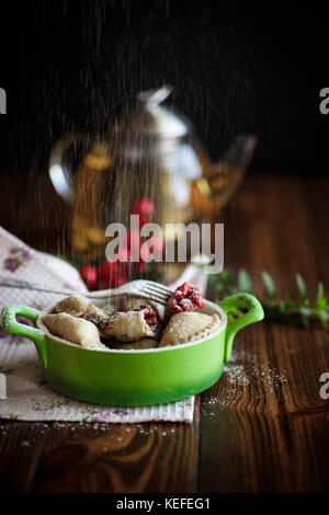 Süße Knödel mit Kirschen in eine Schüssel geben. Stockfoto