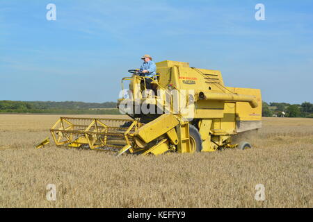 Vintage New Holland open cabyellow Mähdrescher in Aktion auf der Farm, Stockfoto