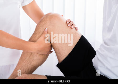 Nahaufnahme eines Therapeuten hand massieren Bein des Menschen in Spa Stockfoto