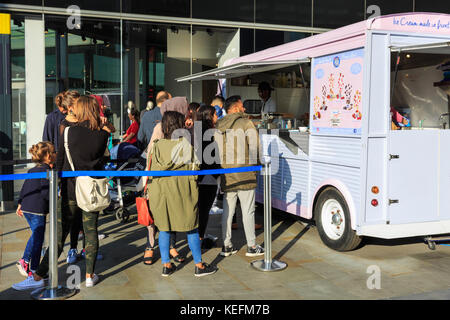 Leute in einer Schlange vor einem altmodischen Pan'n'Ice Brabd-Eiswagen an einem sonnigen Tag in London, England Stockfoto
