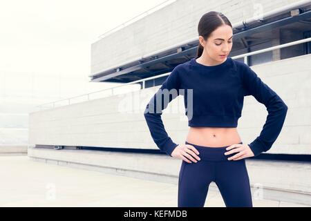 MODEL RELEASED. Junge Frau im Sport Kleidung auf den Hüften. Stockfoto