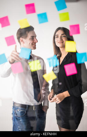 Start up Business Planung und Organisation mit junges Paar an moderne Büro innen schreiben Notizen auf Aufkleber Stockfoto