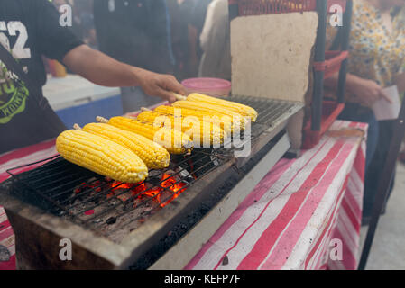 Maiskolben kochen über Holzkohle Grill auf einem asiatischen Street Food stall. Stockfoto