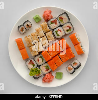 Sushi auf einer runden Platte auf einem weißen Hintergrund. Sushi Roll Nahaufnahme, Ansicht von oben Stockfoto