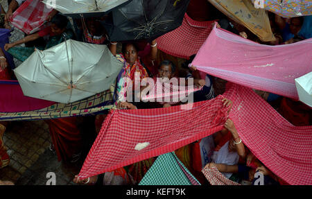 Kolkata, Indien. 19 Okt, 2017. Hindu devotee Hold up Sonnenschirm holly Reis zu erhalten, wie Sie durch einen Tempel Behörde anlässlich der annakut Festival verteilt. Credit: sanjay purkait/Pacific Press/alamy leben Nachrichten Stockfoto