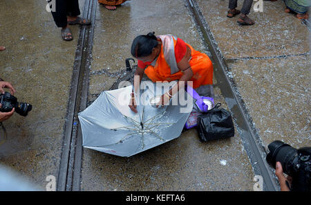 Kolkata, Indien. 19 Okt, 2017. Hindu devotee Hold up Sonnenschirm holly Reis zu erhalten, wie Sie durch einen Tempel Behörde anlässlich der annakut Festival verteilt. Credit: sanjay purkait/Pacific Press/alamy leben Nachrichten Stockfoto