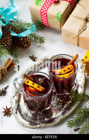 Hausgemachte Weihnachten cocktail Glühwein Rotwein mit Zimtstangen, Orangen und Nelken, in zwei Tassen serviert auf einem grauen Stein oder Schiefer. kopieren. Stockfoto