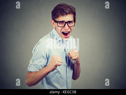 Junger Mann in Rage droht jemand mit Fäusten zu schlagen Stockfoto