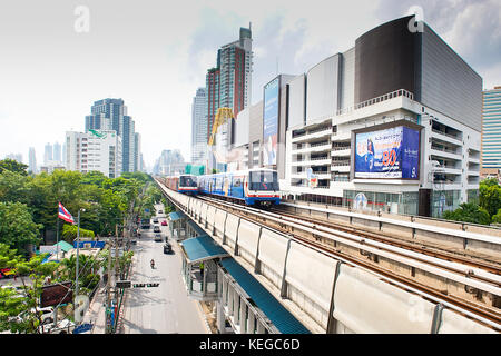 Blick vom Bahnsteig des Skytrain-Bahnhofs Der Zug nähert sich der Stadt Bangkok Thailand Mit der stark befahrenen Straße unten und der Stockfoto