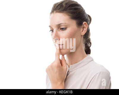 Nachdenkliche junge Frau denken und berühren ihre Lippen, weißer Hintergrund Stockfoto