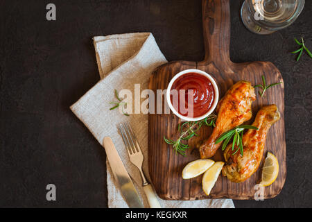 Gegrillte pikante Huhn drumstick wird auf einem Holzbrett serviert. Ansicht von oben mit der Kopie Raum Stockfoto