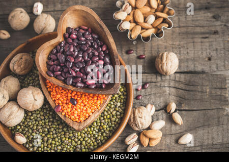 Quellen von pflanzlichen Proteinen sind verschiedene Hülsenfrüchte und Nüsse. Ansicht von oben mit der Kopie. Stockfoto