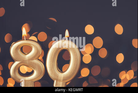 Gold Nummer 80 Feier Kerze gegen Licht Hintergrund verschwommen Stockfoto