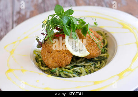 Krabbenkuchen mit Zucchini pasta garniert mit Kresse Stockfoto