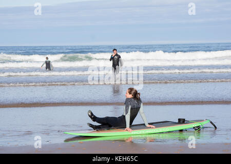 Surfen auf Bamburgh Beach, Northumberland, England, Großbritannien Stockfoto