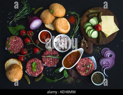Zutaten zum Kochen Burger. rohes Hackfleisch Fleisch Schnitzel, Brötchen, roten Zwiebeln, Tomaten, grüne, Essiggurken, Tomatensoße, Käse, Kräutern und spic Stockfoto