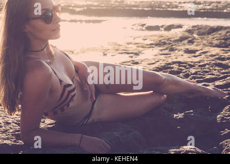 Kaukasische Frau liegt am Strand trägt Bikini Stockfoto