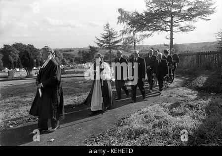 Die Mitglieder des Klerus und Officals weihen eine Grabstätte auf einem Sportplatz Friedhof weihe Service 1968 Stockfoto