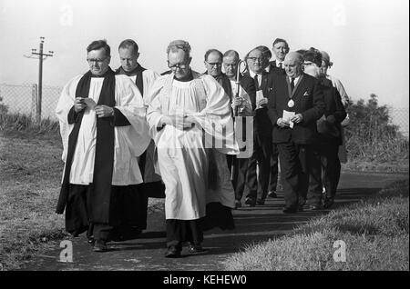 Die Mitglieder des Klerus und Officals weihen eine Grabstätte auf einem Sportplatz Friedhof weihe Service 1968 Stockfoto