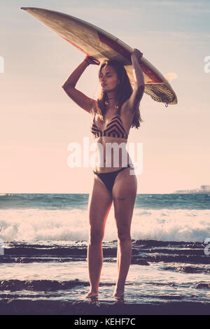 Kaukasische Frau am Strand holding Surfboard Stockfoto