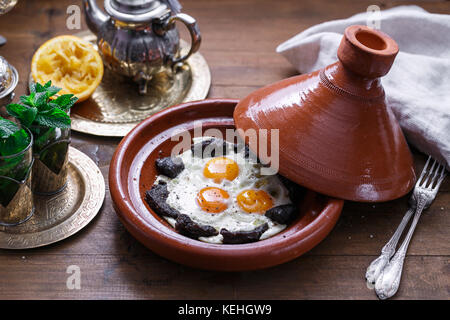 Spiegeleier und Rindfleisch in Tajine Schale mit Deckel, marokkanisches Frühstück. Stockfoto