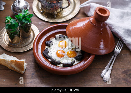 Spiegeleier und Rindfleisch in Tajine Schale mit Deckel, marokkanisches Frühstück. Stockfoto