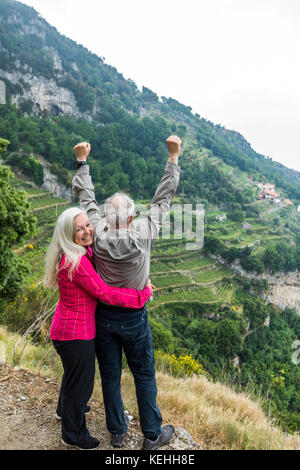 Kaukasisches Paar feiert auf dem Hügel Stockfoto