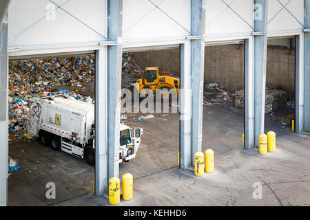 Müllwagen Entladen von Müll Stockfoto