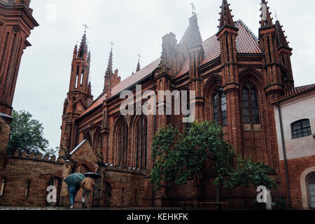 Menschen tragen Sonnenschirme in der Nähe der Kirche Stockfoto