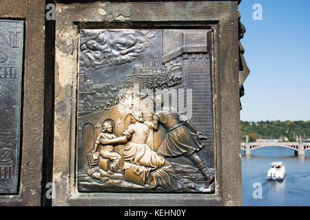 Plakette unter st. Johann von Nepomuk statue Tradition sagt, dass, wenn Sie reiben und die bronzene Plakette touch soll Glück bringen und sicherstellen, dass Ihr retu Stockfoto