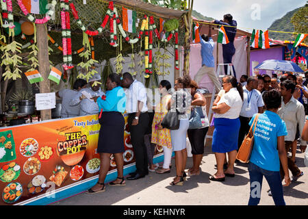 Die Seychellen, Mahe, Victoria, Indien Tag, Schlange von Kunden außerhalb Kupfer Topf indisches Essen Abschaltdruck Stockfoto