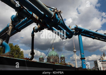 Blau oberirdische Wasserleitungen im Bereich Bau in Unter den Linden in Berlin, Deutschland. Den Berliner Dom und den Fernsehturm (Fernsehturm) sind im Hintergrund zu sehen. Stockfoto