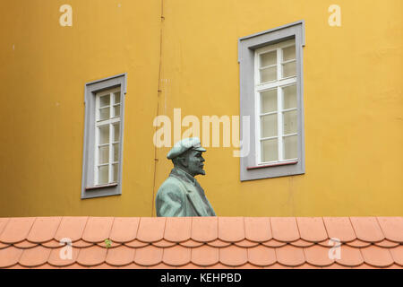 Lenin-denkmal lugen über die Mauer in Cheb, Tschechien. Denkmal der russischen bolschewistischen revolutionären Vladimir Lenin durch tschechische Bildhauer Vladimír Reich (1979) stand einst vor dem Bahnhof und wurde in das lapidarium in der Franziskanischen Gärten (Františkánské zahrady) verschoben Nach dem Zusammenbruch des kommunistischen Regimes in der Tschechoslowakei fiel. Foto von vova Pomortzeff Stockfoto