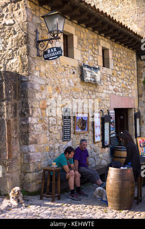 Die einheimischen an einer traditionellen Bar in gepflasterten Straße Calle del Canton in Santillana del Mar, Spanien Stockfoto