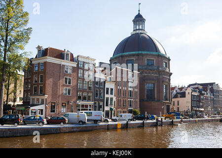 Amsterdam, Niederlande - 23. September 2017: Das schmalste Haus in Amsterdam auf dem Hintergrund der Koepelkerk-Kirche bei sonnigem Tag Stockfoto