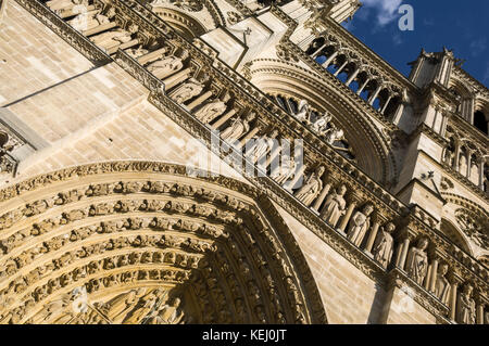 Abstrakte, in einem Winkel, Nahaufnahme, Blick auf das zentrale Portal der Westfassade von Notre Dame, eine französische gotische Kathedrale in Paris. Direkt Suchen und vor blauem Himmel. Stockfoto
