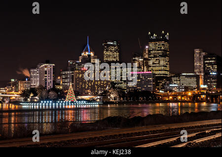 Pittsburgh Skyline während Licht, Nacht, mehrere Wolkenkratzer, Weihnachtsbaum und Allegheny River in Pennsylvania, USA Stockfoto