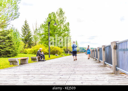 Saguenay, Kanada - Juni 3, 2017: Terrasse Promenade in der Innenstadt von Sommer City Park in Québec mit dem Musiker spielen Akkordeon und Menschen zu Fuß Stockfoto