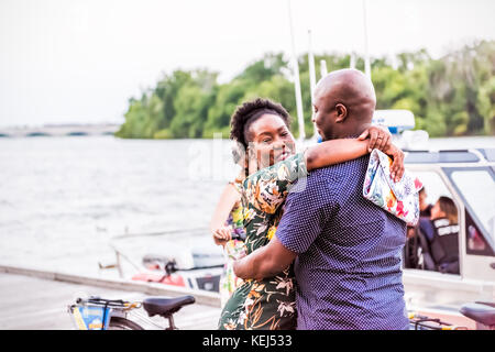 Washington DC, USA - August 4, 2017: Happy African American schwarz Paar lächelnd umarmen und umarmt, in Georgetown Park am Flussufer in e Stockfoto