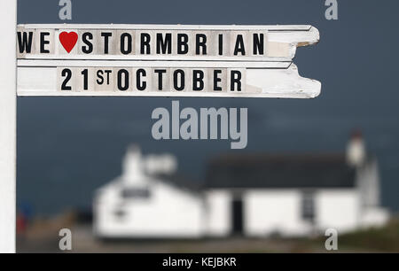 "We love Storm Brian" ist auf dem Lands End Wegweiser in Cornwall zu sehen, als Storm Brian das Vereinigte Königreich mit Winden von bis zu 70 km/h trifft, die Küstengebiete durchbrechen. Stockfoto