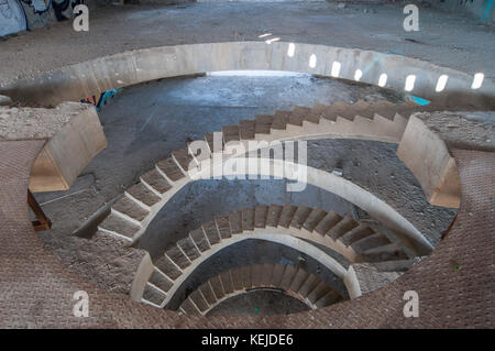 Eine Wendeltreppe aus Beton in einem unvollendeten, verlassenen Gebäude Stockfoto