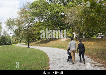 Ein junges Paar mit Baby macht einen morgendlichen Herbstspaziergang im Prospect Park, Brooklyn, New York. Stockfoto