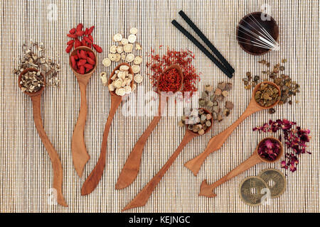 Chinesische Kräutermedizin mit Kräutern in Holzlöffel, Akupunkturnadeln, moxa Sticks in moxibustion Therapie mit Feng Shui Münzen verwendet auf Bambus. Stockfoto