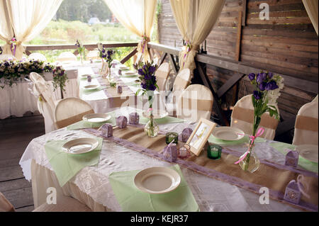 Wunderschön dekorierten Tisch für die Trauung serviert. Bankett Tisch mit frischen Blumen im Freien eingerichtet. Stockfoto
