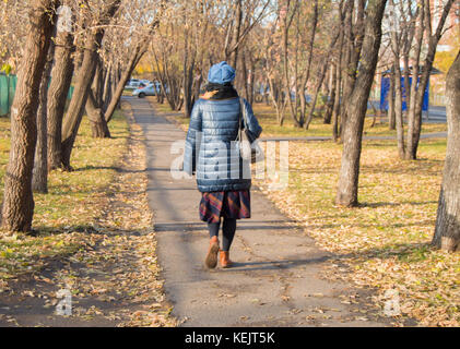 Modisch gekleidete Frau Wandern im Herbst Park. Stockfoto