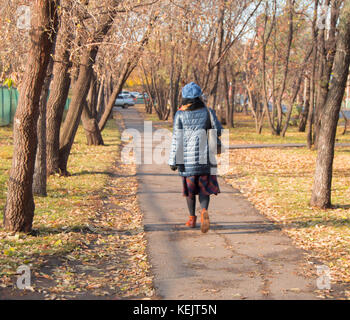 Modisch gekleidete Frau Wandern im Herbst Park. Stockfoto